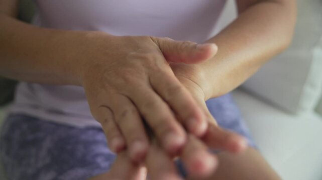 Asia adult aged people middle age happy old woman smile apply collagen cream body oil herb vitamin c e reduce dry arm elbow hand skin health care sit at home sofa elder aging beauty asian female.