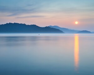 Fototapeta premium Sunrise over misty lake and hills.