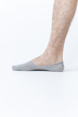 Male leg in short gray sock on white background