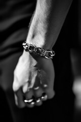 A person wearing a chain around their wrist, possibly symbolizing captivity or bondage