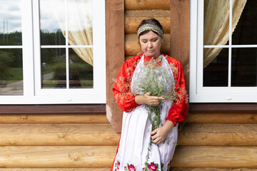 a woman in a national Udmurt costume. small nations.A woman in a national costume stands at the...