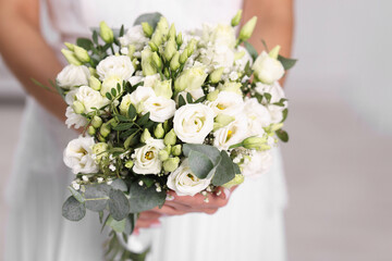 Bride with beautiful wedding bouquet on light background, closeup
