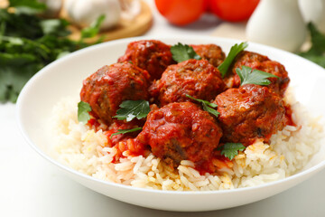 Delicious meatballs with rice, sauce and parsley on white table, closeup