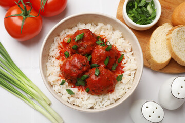 Tasty meatballs with sauce, rice and products on white tiled table, flat lay