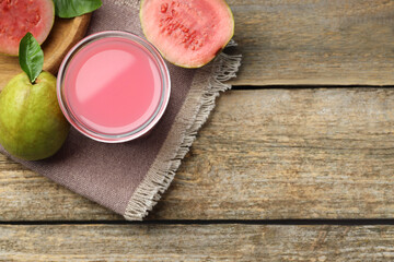 Refreshing guava juice and fresh fruits on wooden table, flat lay. Space for text
