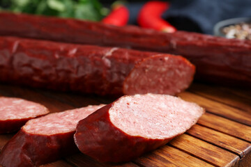 Delicious thin smoked sausage on table, closeup