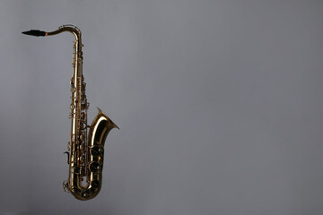 Golden saxophone on grey background. Space for text