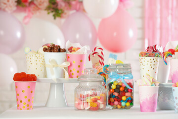 Candy bar. Many different sweets on table in festive decorated room