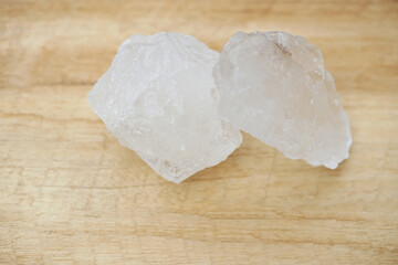 White alum stones on wooden floor background. Thais use it to get rid of body odor and swing the dirty water to make water clear. Useful for beauty and spa treatment. Use to treat cracked heels  