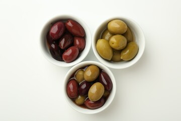 Tasty marinated olives in bowls on white table, flat lay