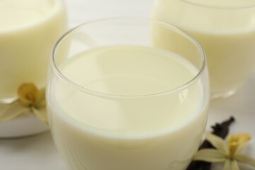 Delicious vanilla milk in glasses on white table, closeup