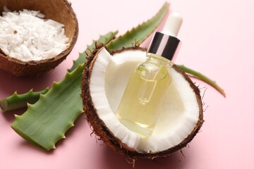 Hair treatment. Cosmetic product, coconut, butter and aloe leaves on pink background, closeup