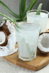 Refreshing drink with coconut and aloe on white textured table, closeup