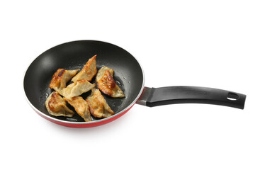 Tasty fried gyoza (dumplings) in frying pan isolated on white
