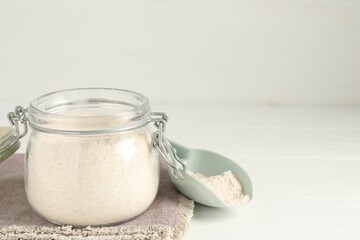 Brown rice flour on white wooden table. Space for text