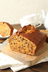 Cut homemade carrot cake with nuts on wooden table, closeup