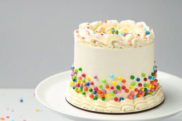 Delicious bento cake with colorful sprinkles on light table, space for text