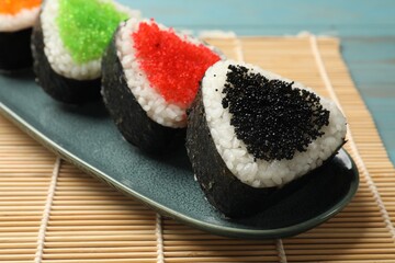 Tasty tobiko onigiri (Japanese rice balls) on table, closeup