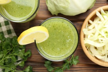 Healthy parsley drink in glasses, lemons and cabbage on wooden table, flat lay
