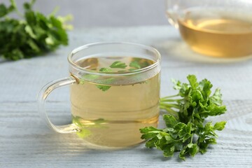 Healthy parsley tea on grey wooden table, closeup. Detox drink