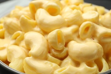 Delicious macaroni and cheese on table, closeup