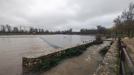 Crecida de río por abundantes lluvias un día lluvioso en Burgos, España