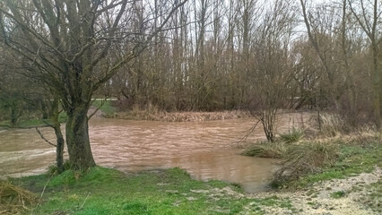 Crecida de río por abundantes lluvias un día lluvioso en Burgos, España