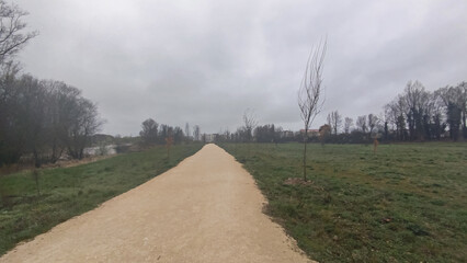 Camino de tierra con vistas de la ciudad de Burgos, España un día nublado y lluvioso