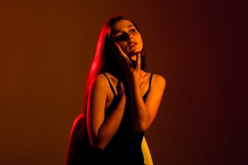 Portrait of a young woman in deep thought during a dramatic lighting session in a studio