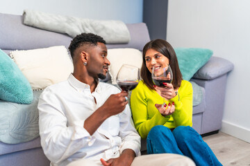 Obraz premium Multiethnic couple enjoying wine together at home