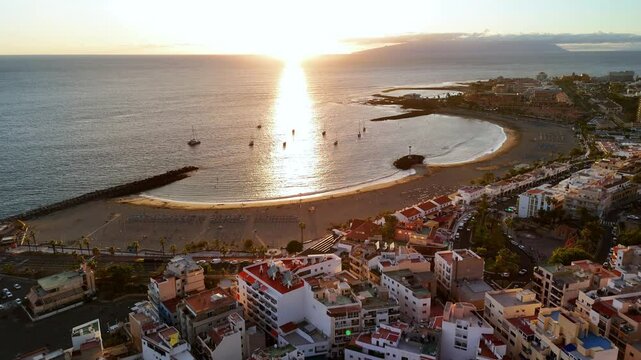 Enjoying the sunset over Los Cristianos beach in Tenerife with beautiful shoreline and lively atmosphere