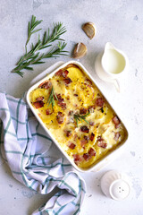 Potato gratin with bacon - traditional dish of french cuisine. Vegetables baked in milk sauce with cheese.