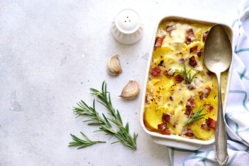 Potato gratin with bacon - traditional dish of french cuisine. Vegetables baked in milk sauce with...