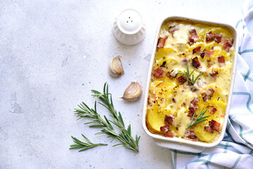 Potato gratin with bacon - traditional dish of french cuisine. Vegetables baked in milk sauce with cheese.