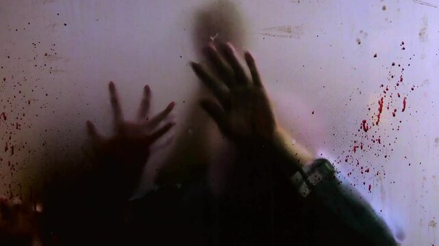 Bloodstained hands sliding across grimy glass surface, creating haunting visual sequence conveying overwhelming sense of terror, isolation, and impending doom with visceral horror aesthetics