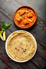 Kerala foods background- spicy coconut mango fish curry served with malabar porotta, parotta.