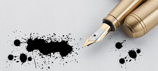 Old golden Fountain Pen on a white paper sheet