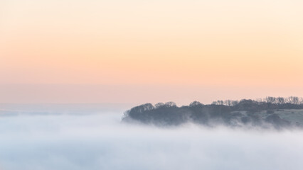 Stunning landscape sunrise image of atmospheric cloud inversion over South Downs escarpment
