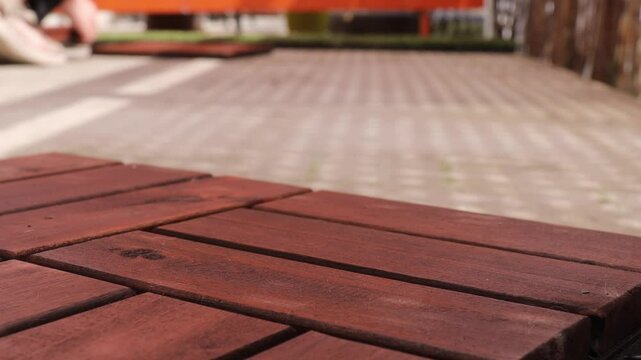 Time-lapse of laying wooden panels on balcony floor. Fast installation of interlocking deck tiles for outdoor upgrade. Balcony renovation with warm wood texture.