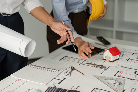 Design Development and Analysis. Professionals analyzing architectural blueprints and designs in an office setting.