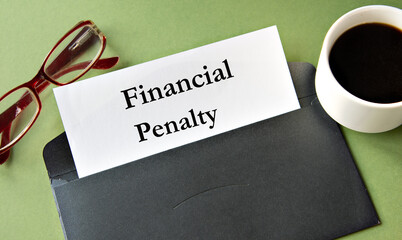 FINANCIAL PENALTY - words on a white sheet of paper on a background of a black convers and a cup of...