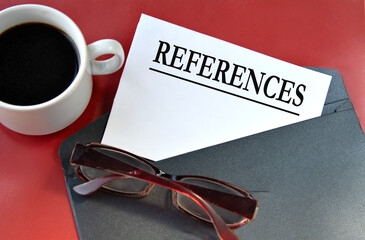 REFERENCES - word on white paper lying on a black envelope on a red background