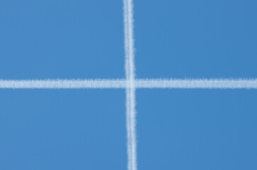 Aircraft Contrails Forming Cross Pattern in Blue Sky