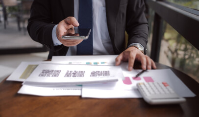 Businessman scanning QR code on smartphone for digital payment. Concept of fintech, cashless transactions, e-commerce, online banking, and financial technology.