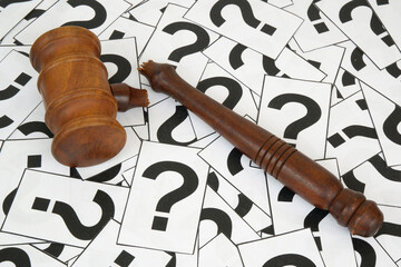 Lawlessness and legal questions concept. Broken gavel on question marks.