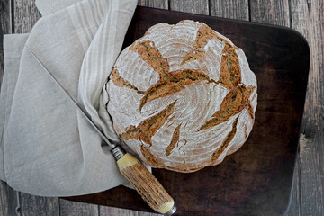 Homemade loaf of bread on a cloth and rustic stag horn knife