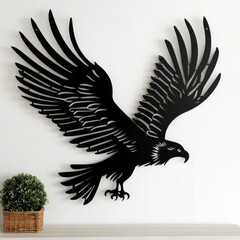 Naklejka premium A black metal eagle on a white wall next to a plant
