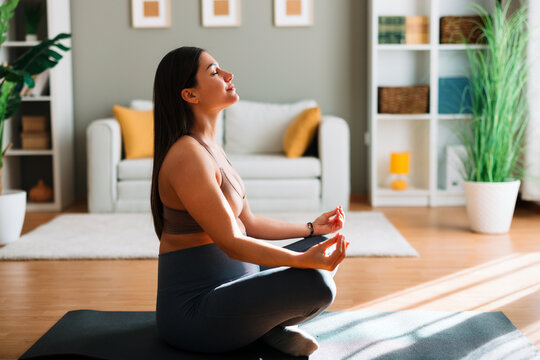 Pregnant woman doing yoga and meditation at home for mindfulness and serenity