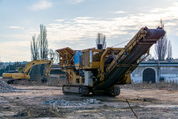 jaw crusher. construction machinery. Demolition of a residential building in the city center made...