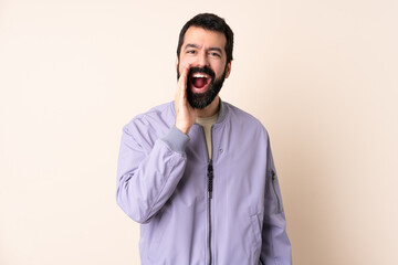 Caucasian man with beard wearing a jacket over isolated background shouting with mouth wide open